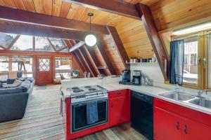 a kitchen with a red stove top oven next to a couch at Hot Tub and Fire Pit Cozy Cabin in Red Lodge! in Red Lodge