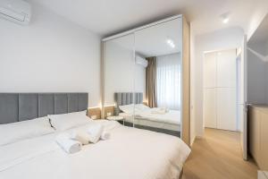 En eller flere senge i et værelse på Cortina North Premium Smart Apartment with Parking