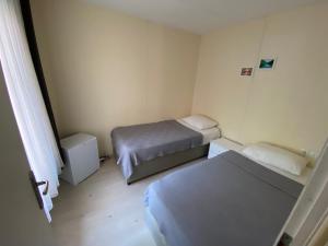 a small room with two beds and a window at Ali Baba Butik Otel in Gündoğdu