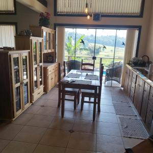 a kitchen with a table and chairs and a window at Casa Suíça família-luxo nr4 Suite master 5-pessoas in Pomerode