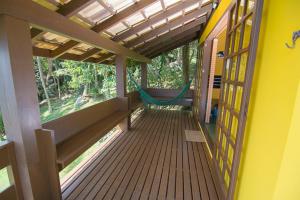 a porch of a house with a bench on it at Cabanas Do Araçá Villa in Porto Belo +54 photos