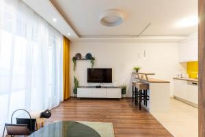 a kitchen and living room with a television and a table at Lakeview Apartment Fonyód in Fonyód