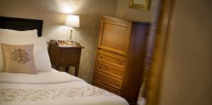 a bedroom with a bed and a dresser with a lamp at Angelis in Prague