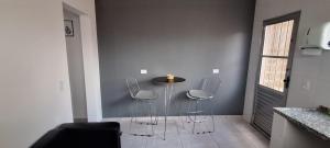 a dining room with two chairs and a table in a room at Araçariguama in Araçariguama