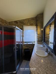 a stone bathroom with two sinks and a shower at Quinta Do Larai in Vale de Cambra +44 photos