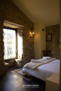 a bedroom with a bed and a large window at Quinta Do Larai in Vale de Cambra