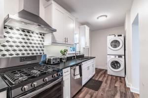a kitchen with a stove and a washer and dryer at Designer Sun Filled Condo - Walk to Town in St Petersburg