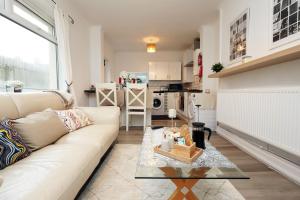 a living room with a white couch and a kitchen at Cardiff City Guesthouse, Central Rooms, Fast Wi-Fi, On-Street Parking in Cardiff