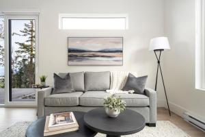 a living room with a couch and a table at Mountain Suite - Fully Equipped Kitchen - Heated Bathroom Floor - Ocean View Fire Pit - WD in Nanaimo