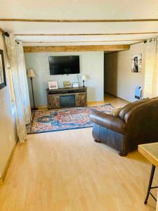 a living room with a couch and a flat screen tv at Bryce Canyon Country House in Hatch