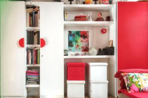 a white book shelf with a red chair in a room at Maison charmante près d'Avignon avec terrasse in Avignon