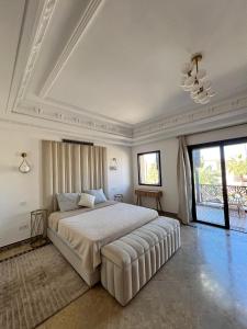 a bedroom with a large bed with a white ceiling at Villa Marrakech piscine in Marrakech
