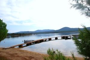a dock on a river with a boat in the water at Residence Ribellinu in Pianottoli-Caldarello