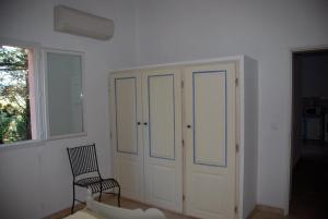 a room with a cabinet and a chair and a window at Residence Ribellinu in Pianottoli-Caldarello
