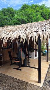 a straw roof of a house with a chair and a table at M and D Inland Resort in Digos