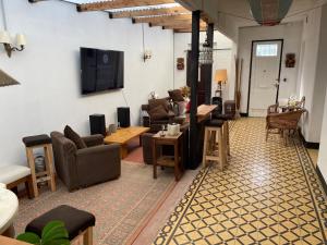 a living room with couches and a flat screen tv at Casa Alvear in Mar del Plata