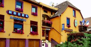 a yellow building with flower boxes on the side of it at Hotel Restaurant Cristal in Wintzenheim