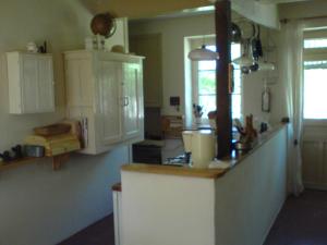 a kitchen with white cabinets and a counter top at Les Champys in Saint-Péreuse