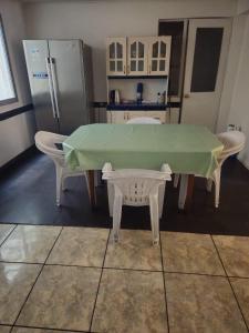 a kitchen with a table with two chairs and a refrigerator at Cómoda Casa Cerca de la playa y el Mall 3B, 3D in Iquique