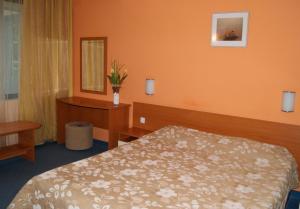 Habitación de hotel con cama y espejo en Hotel Fors en Burgas