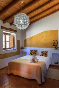 a bedroom with a large bed and a chandelier at Monte da Boavista in São Teotónio