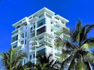 un bâtiment blanc avec des palmiers devant dans l'établissement New Apartments with great Sunsets near historic center and beach, à Carthagène des Indes