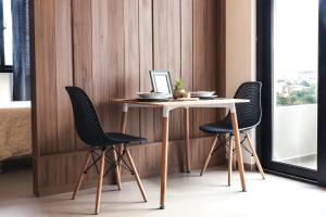 einem Tisch mit zwei Stühlen und einem Laptop darauf in der Unterkunft El mirador, moderno y acogedor departamento con balcon privado in Tarija