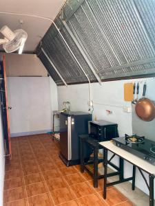 a room with a kitchen with a table and a stove at Solar cell rental house in Chiang Rai