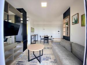 a living room with a couch and a table at Apartamento Wi-fi, Split, Estacionamento e Piscina in Ribeirão Preto