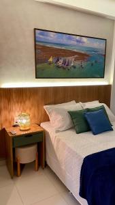a bedroom with a bed and a desk with a painting on the wall at Malia Muro Alto - Porto de Galinhas - Flat para 5 pessoas vista piscinas in Ipojuca +29 photos