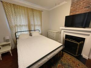 Schlafzimmer mit einem Bett, einem Kamin und einem TV in der Unterkunft Sparkle City Cottage in Spartanburg