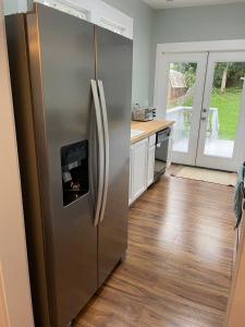 Ein Edelstahlkühlschrank in einer Küche mit Holzboden in der Unterkunft Sparkle City Cottage in Spartanburg
