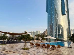 アブダビにあるSea Breeze 1BR in Luxury Complex with Sea View Pools Gym on Reem Islandのリゾート(プール、椅子付)