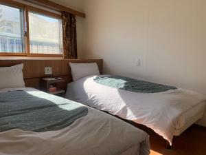 Postel nebo postele na pokoji v ubytování Izu-no-umi Hotel