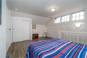 a bedroom with a bed with a striped blanket and a window at Woodley Beach House in Lincoln Beach +12 photos