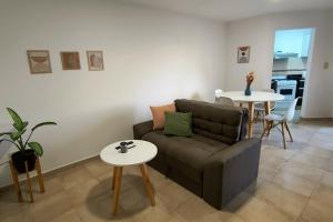 ein Wohnzimmer mit einer Couch und zwei Tischen in der Unterkunft Departamento Moderno - Punto Alto in Villa María