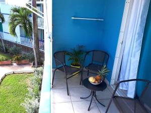 Un patio con dos sillas y una mesa con un bol de fruta. en Studio vue Mer Gosier, Guadeloupe, en Le Gosier