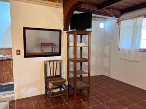 una camera con TV, sedia e specchio di Posada Quetzalin a Cuetzalan del Progreso