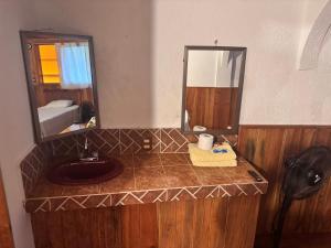 un bagno con lavandino e specchio di Posada Quetzalin a Cuetzalan del Progreso