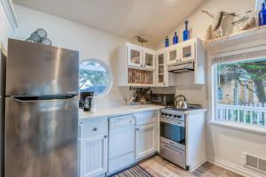 a kitchen with white cabinets and a stainless steel refrigerator at Rememberance in Depoe Bay
