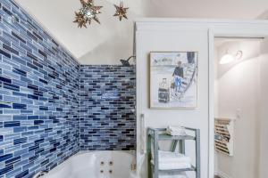 a bathroom with a tub and a blue tiled wall at Rememberance in Depoe Bay