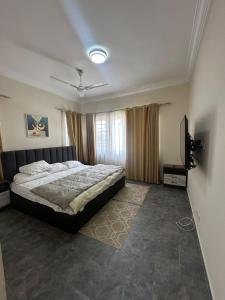 une chambre avec un lit et une télévision à écran plat dans l'établissement Luxury East Legon Hills A gated 3-Bedroom house - Fivehills Homes, à Maijaw 5 autres photos