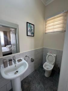 une salle de bain avec un lavabo, des toilettes et un miroir dans l'établissement Luxury East Legon Hills A gated 3-Bedroom house - Fivehills Homes, à Maijaw