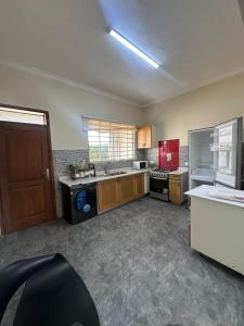 une grande cuisine avec des placards en bois et des appareils rouges dans l'établissement Luxury East Legon Hills A gated 3-Bedroom house - Fivehills Homes, à Maijaw