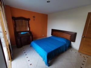 a bedroom with a blue bed and a dresser at Casa de descanso en mesitas del colegio VILLA LUZ in El Colegio +27 photos