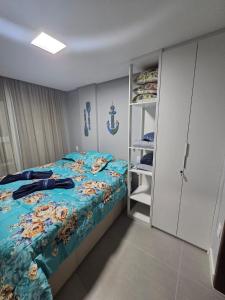 a bedroom with a bed with a blue comforter at Charme e requinte em Carneiros com 2 quartos in Tamandaré +25 photos