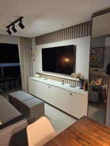 a living room with a large flat screen tv at Charme e requinte em Carneiros com 2 quartos in Tamandaré