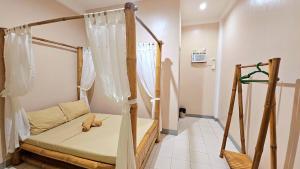 een kleine kamer met een bed met gordijnen bij Mangoverde Guesthouse in Moalboal +7 foto's