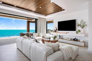 a living room with a white couch and a tv at Villa Julia and Villa Angelina in Leeward