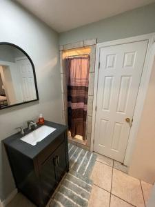 ein Badezimmer mit einem schwarzen Waschbecken und einem Spiegel in der Unterkunft Carolina Cottage in Spartanburg